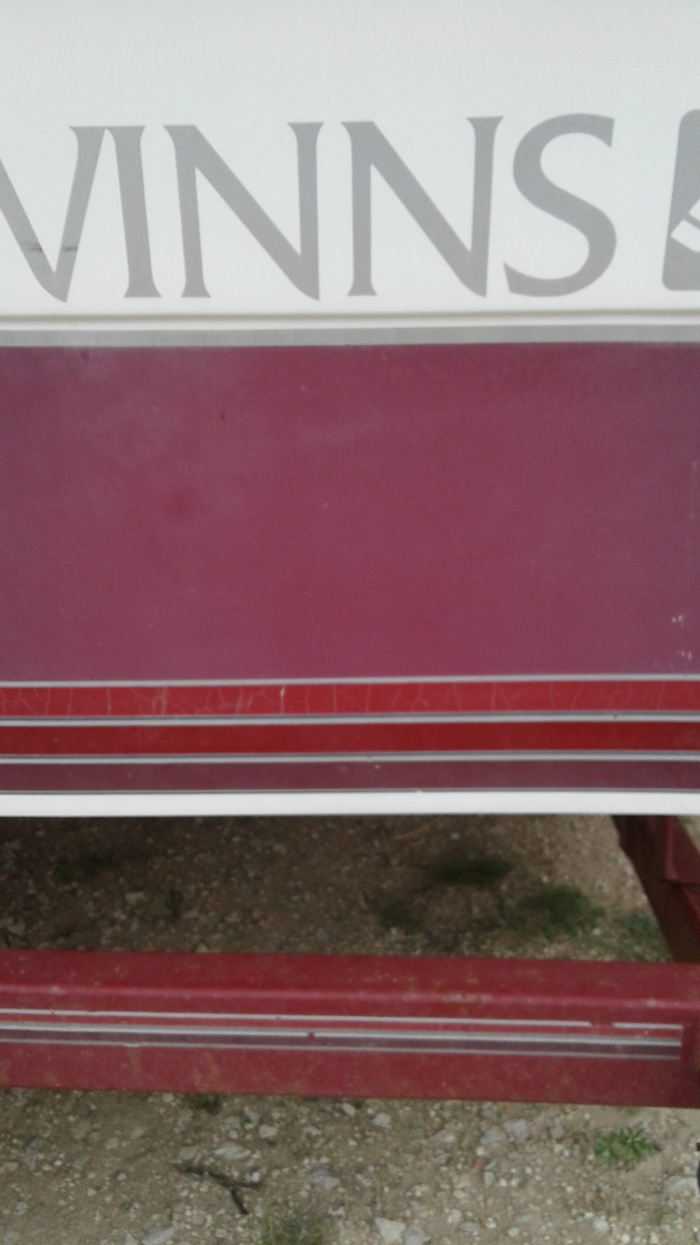 Faded and oxidized red and white hull color on boat