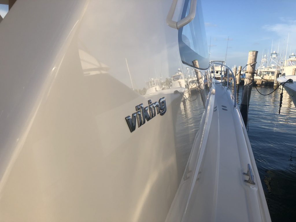 Starboard of viking sitting in the water at a marina with reflection off the surface after Glidecoat yacht ceramic coating application