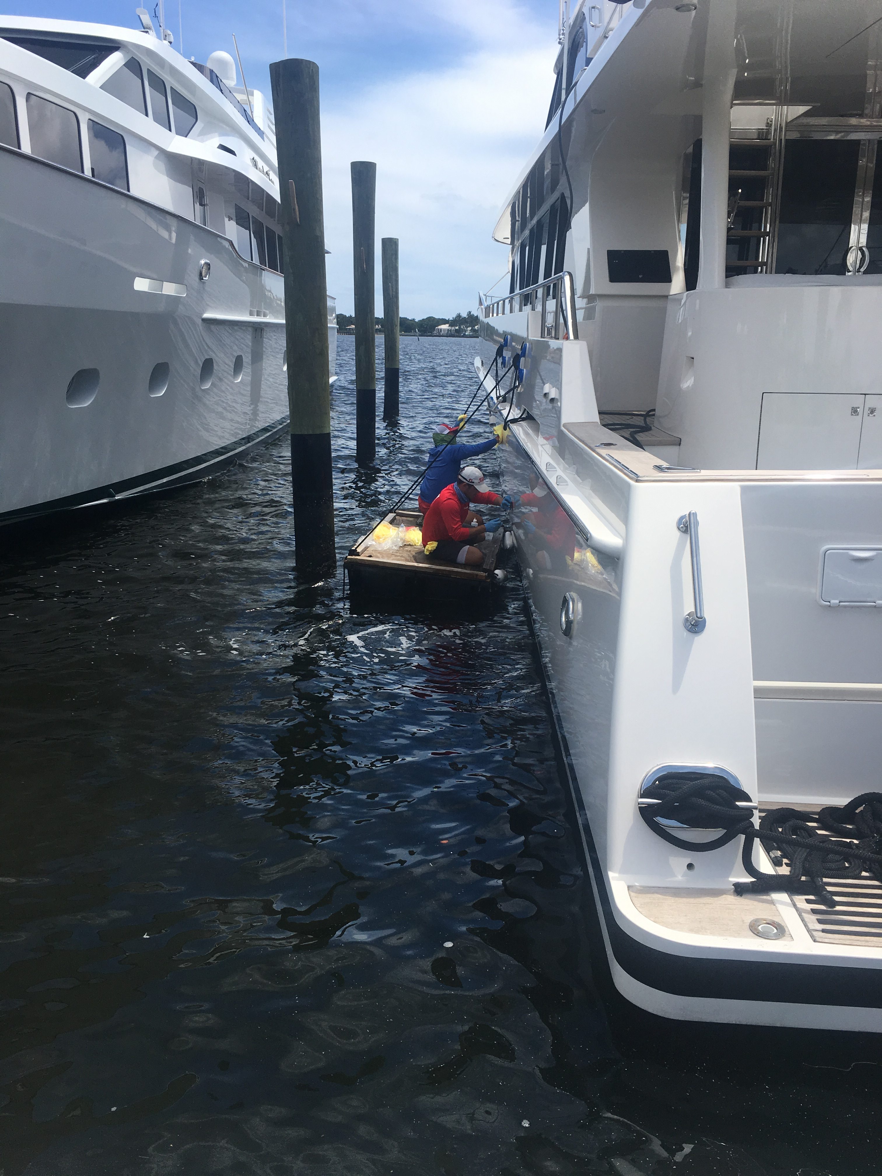 Two Glidecoat technicians working on a raft on the port side of the boat